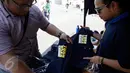 Calon pembeli melihat baju bertulisan "Turn Back Crime" yang dijual saat Car Free Day dikawasan Bunderan HI, Jakarta, Minggu (13/3). Penggunaan merk 'Turn Back Crime' bertujuan untuk kampanye waspada tindak kejahatan. (Liputan6.com/Faizal Fanani)