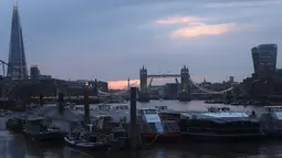Pemandangan Tower Bridge, tengah, di Sungai Thames saat matahari terbenam di London pada Senin (9/8/2021). Tower Bridge London macet terbuka karena kesalahan teknis mengakibatkan gangguan lalu lintas di kedua sisi Sungai Thames karena mobil dan pejalan kaki tidak dapat menyeberang. (AP/Tony Hicks)