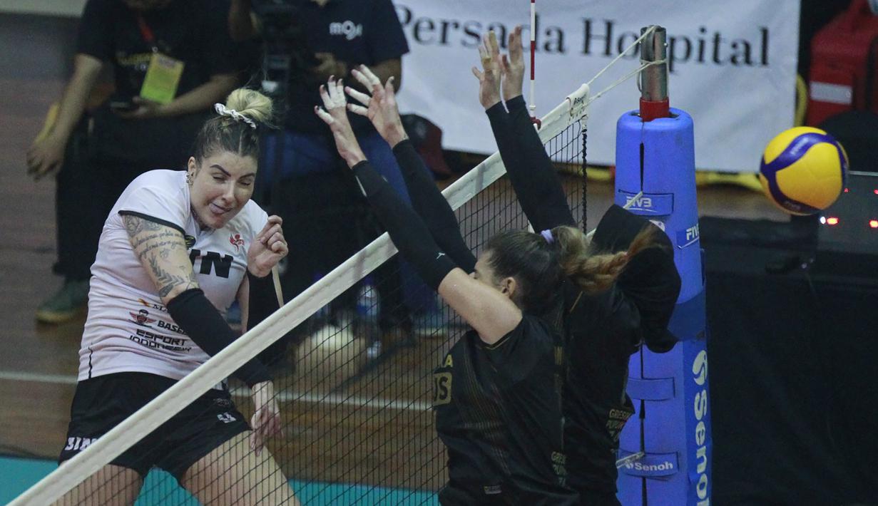 Pemain Jakarta BIN, Fernanda Davis Tome melepaskan spike yang berusaha diblok dua pemain Gresik Petrokimia Pupuk Indonesia dalam laga seri kedua putaran kedua Proliga 2023 di GOR Ken Arok, Malang, Kamis (9/2/2023) siang WIB. Jakarta BIN kalah 2-3 (25-23, 21-25, 25-20, 17-25 dan 9-15). (Dok. Proliga 2023)