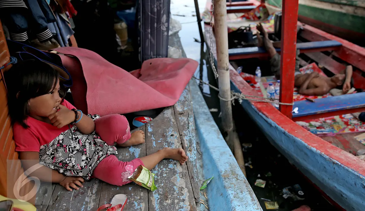 Seorang anak duduk di atas kapal pasca penggusuran permukiman Pasar Ikan, Jakarta, Selasa (13/4/2016). Warga Pasar Ikan mengaku belum mendapat rumah susun sewa yang telah dijanjikan oleh Pemprov DKI Jakarta. (Liputan6.com/Faizal Fanani)