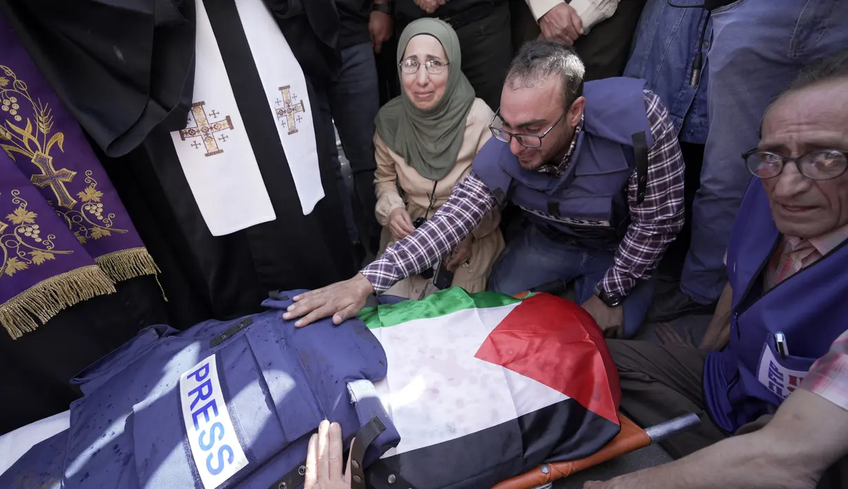 Sejumlah wartawan berkumpul sekitar jenazah wartawan Al Jazeera Shireen Abu Akleh di Kota Jenin, Tepi Barat, Rabu (11/5/2022). Menurut Kementerian Kesehatan Palestina, Shireen Abu Akleh tewas ditembak saat meliput serangan Israel di Kota Jenin. (AP Photo/Majdi Mohammed)