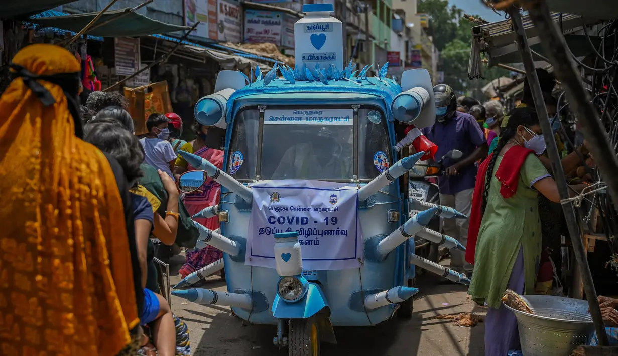 Sebuah bajaj yang dihias dengan replika jarum suntik besar melintasi jalanan di Chennai, India, Sabtu (3/6/2021). Seorang seniman di Chennai menghias bajaj tersebut untuk meningkatkan kesadaran orang-orang tentang pentingnya vaksinasi Covid-19 di tengah sejumlah temuan varian baru. (Arun SANKAR/AFP)