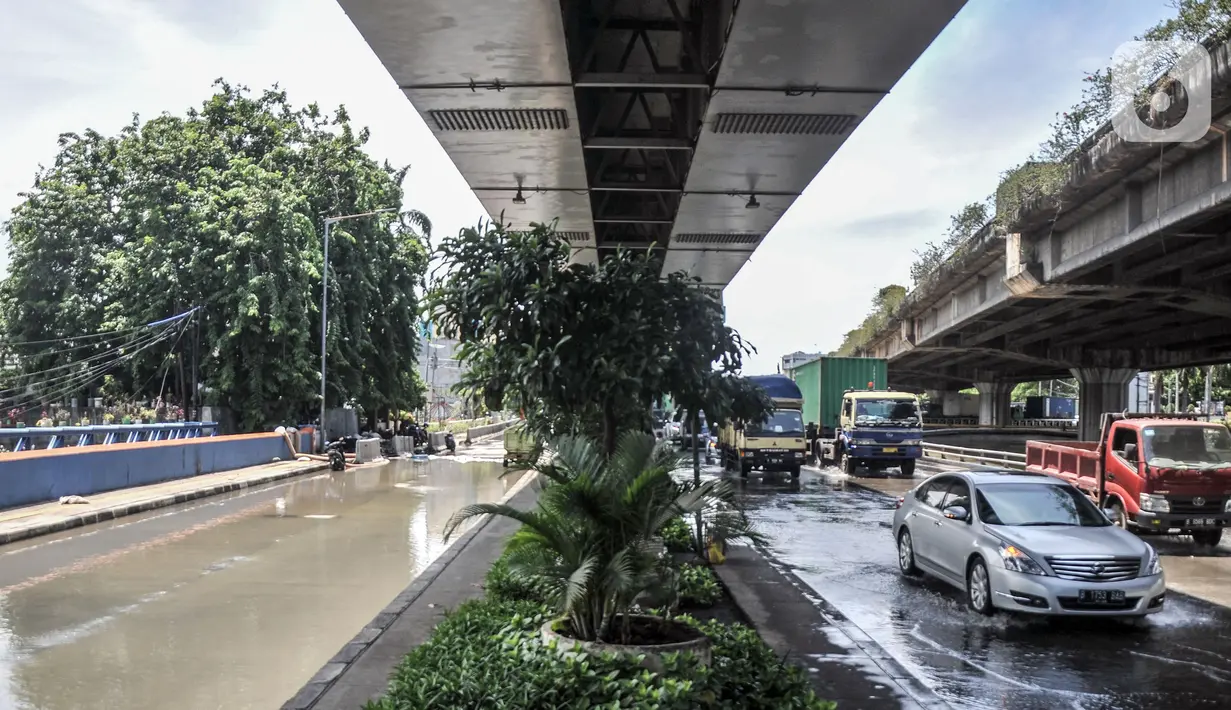 Kendaraan melintas dekat lokasi banjir di Jalan RE Martadinata, Ancol, Jakarta, Selasa (9/11/2021). Banjir disebabkan oleh meluapnya Kali Ciliwung Gunung Sahari dan ditambah fenomena air pasang laut yang terus terjadi. (merdeka.com/Iqbal S. Nugroho)