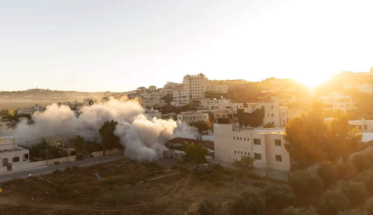Matahari terbit saat unit tentara Israel menghancurkan rumah warga Palestina Amerika Muntasser Shalaby menggunakan ledakan terkendali, di desa Turmus Ayya, Tepi Barat, utara Ramallah (8/7/2021). (AP Photo/Nasser Nasser)