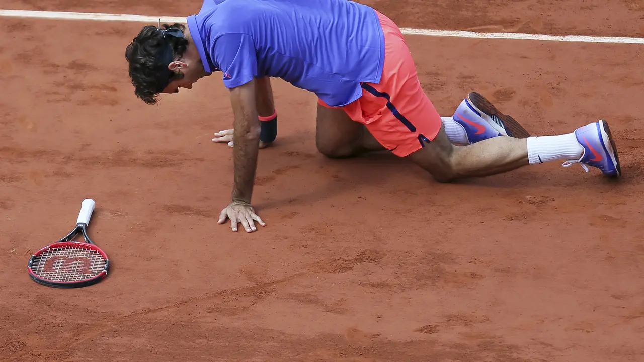 Roger Federer terpeleset pada perempat final Prancis Terbuka 2015 melawan Stan Wawrinka. Federer memilih absen di grand slam tersebut tahun ini. (AP Photo/David Vincent)