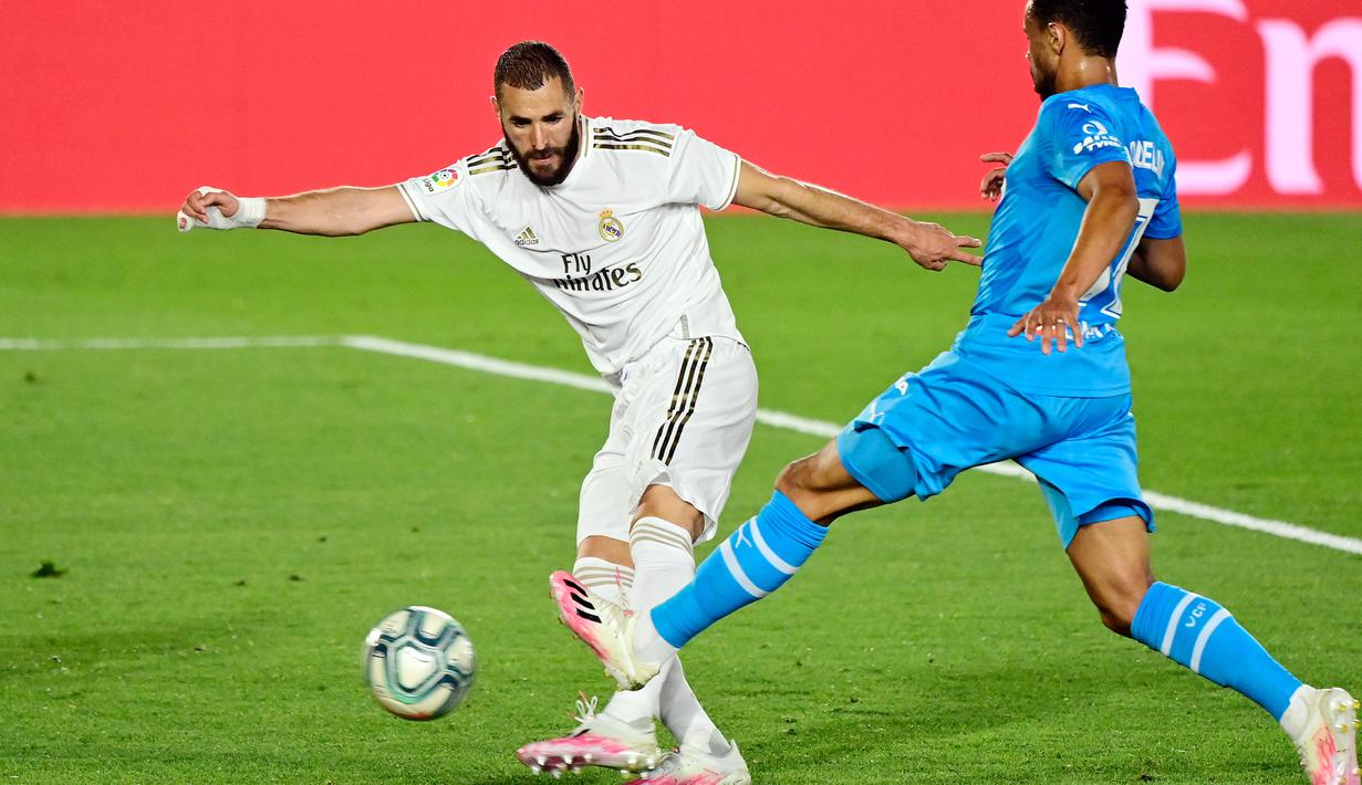 Striker Real Madrid, Karim Benzema, berebut bola dengan gelandang Valencia, Francis Coquelin, pada laga lanjutan La Liga Spanyol pekan ke-29 di Stadion Alfredo, Stefano, Jumat  (19/6/2020) dini hari WIB. Real Madrid menang 3-0 atas Valencia. (AFP/Javier Soriano)