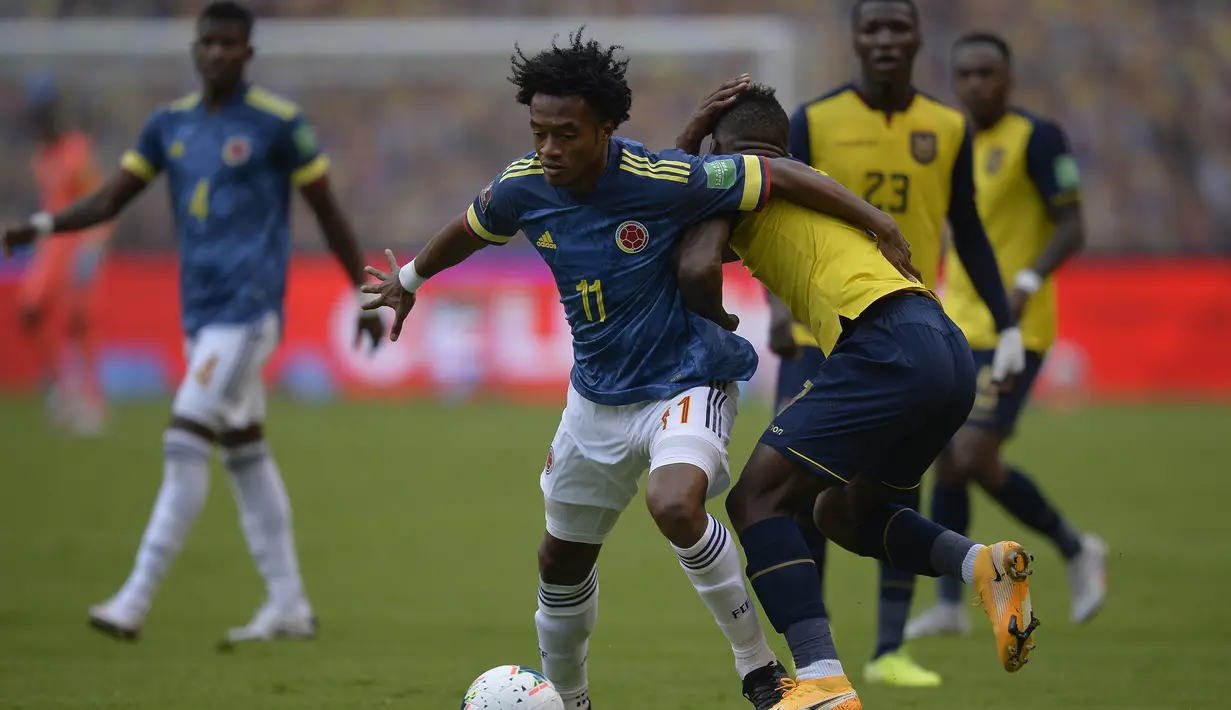 Pemain Kolombia, Juan Cuadrado (kiri), berebut bola dengan pemain Ekuador, Pervis Estupinan, dalam laga lanjutan kualifikasi Piala Dunia 2022 zona CONMEBOL melawan Ekuador di Rodrigo Paz Delgado Stadium, Quito, Ekuador, Rabu (18/11/2020) pagi WIB. Kolombia kalah 1-6.  (AFP/Rodrigo Buendia/Pool)