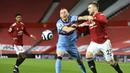 Bek Manchester United, Luke Shaw, berebut bola dengan pemain West Ham United, Vladimir Coufal, pada laga Liga Inggris di Stadion Old Trafford, Minggu (15/3/2021). Setan Merah menang dengan skor 1-0. (AP/Clive Brunskill,Pool)