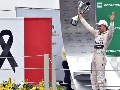 Nico Rosberg memenangi F1 GP Brasil di Sirkuit Interlagos, Sao Paulo, Brasil, Senin (16/11/2015) dini hari WIB. Rosberg mendedikasikan kemenangannya untuk korban teror bom di Paris, Prancis. (AFP Photo/Nelson Almeida)