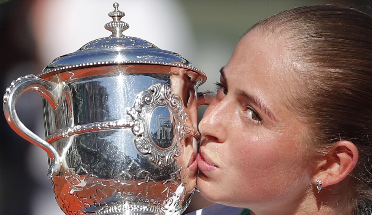  Jelena Ostapenko mencium trofi juara usai mengalahkan petenis Rumania, Simona Halep pada Final Prancis Terbuka 2017 di Roland Garros, Paris, (10/6/2017). Ostapenko menang 4-6, 6-4, 6-3. (AP/Christophe Ena)