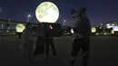 Warga berswafoto dekat instalasi bulan purnama yang bersinar di sebuah taman di Seoul, Korea Selatan, Jumat (18/9/2020). Pejabat setempat memasang bulan purnama buatan untuk meningkatkan semangat saat wabah COVID-19 sekaligus menyambut Chuseok, Thanksgiving versi Korea. (AP Photo/Ahn Young-joon)