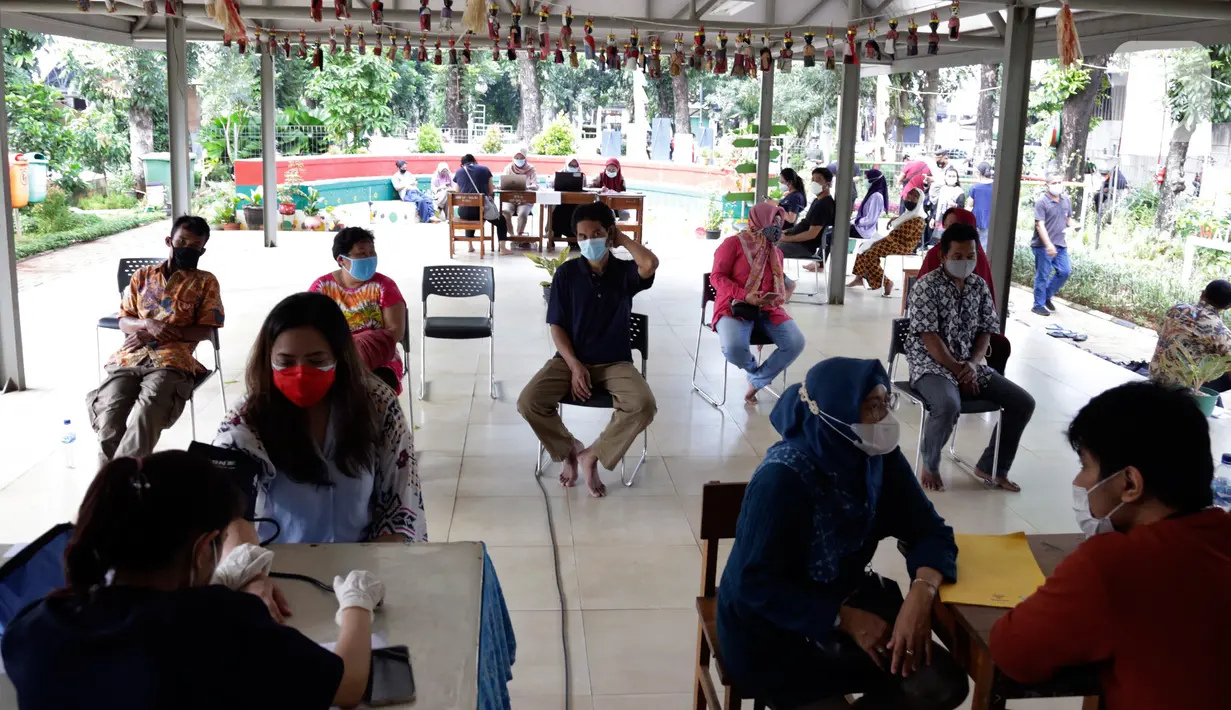 Warga menunggu dalam antre untuk vaksinasi COVID-19 di RPTRA Taman Gajah, Cipete Selatan, Jakarta, Kamis (27/5/2021). Pemprov DKI Jakarta melakukan vaksinasi COVID-19 bagi warga usia 18 tahun ke atas yang berada di RW rentan dan padat penduduk. (Liputan6.com/Johan Tallo)