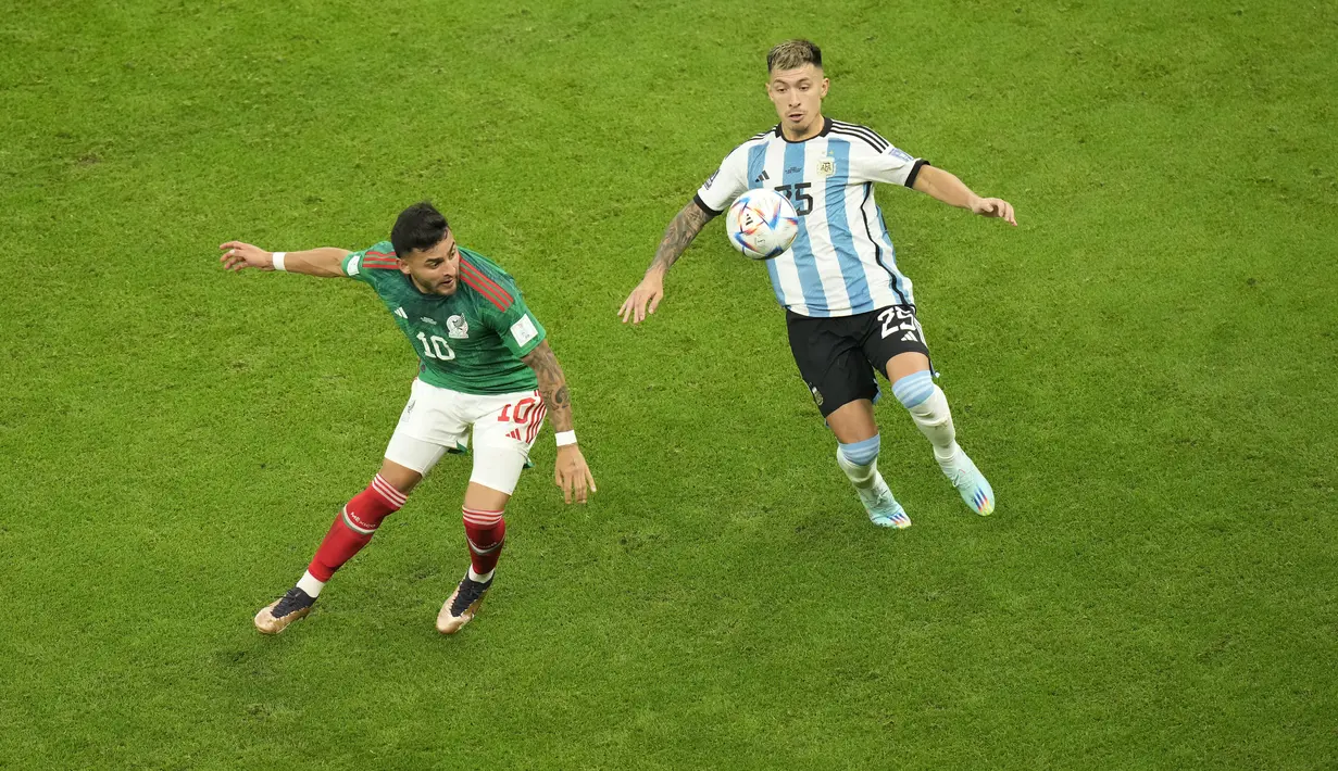Penyerang Meksiko,  Alexis Vega berebut bola dengan bek Argentina, Lisandro Martinez  selama pertandingan grup C Piala Dunia 2022 Qatar di Stadion Lusail di Lusail, Qatar, Minggu 27 November 2022. Argentina  kini berada diuturan kedua klasemen dengan dua poin. (AP Photo/Darko Bandic)