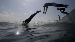 Perenang melompat ke air dalam lomba renang maraton internasiona di pantai Copacabana, Rio de Janeiro, Brazil. (Reuters/Ricardo Moraes)