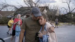 Michael Talamantez menghibur pacarnya Derry Schroer setelah rumah Talamantez di Stratford Drive di Round Rock, Texas dihancurkan badai tornado, ketika mereka berada di dalam rumah, Senin (21/3/2022). "Saya pikir saya akan mati ," dia berkata. (Jay Janner/Austin American-Statesman via AP)