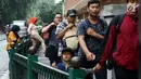 Sejumlah orang berjalan saat beberapa penumpang memanjat pagar pembatas di Stasiun Cikini, Jakarta, Rabu, (20/12). Akses pintu keluar stasiun yang terlalu jauh membuat banyak penumpang mencari jalan pintas dengan melompat pagar. (Liputan6.com/Johan Tallo)