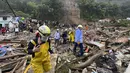 Petugas penyelamat mencari korban selamat di mana lereng bukit yang diguyur hujan runtuh menimpa rumah-rumah penduduk di Pereira, Kolombia, Selasa (8/2/2022). (AP Photo/Andres Otalvaro)