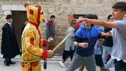 Pria berkostum setan mengejar kerumunan orang selama tradisi melompati bayi (El Colacho) di desa Castrillo de Murcia, Minggu (3/6). Festival ini dimulai ketika kerumunan orang termasuk para orang tua dari bayi-bayi  sudah berkumpul. (AFP/CESAR MANSO)