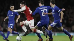 Aksi pemain Arsenal, Mesut Ozil melewati kepungan pemain Chelsea pada laga semifinal Piala Liga Inggirs di Emirates stadium, London, (24/1/2018). Arsenal menang 2-1. (AP/Matt Dunham)