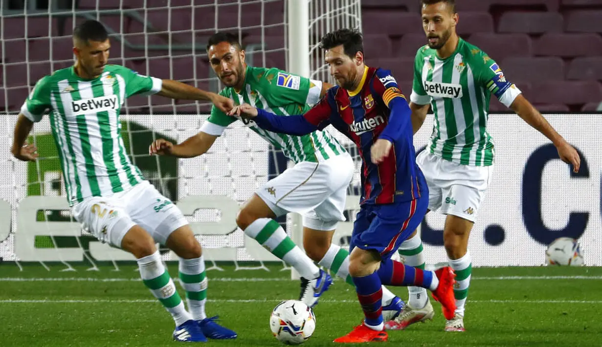 Striker Barcelona, Lionel Messi, berusaha melewati pemain Real Betis pada laga La Liga di Stadion Camp Nou, Sabtu (7/11/2020). Barca menang dengan skor 5-2.(AP/Joan Monfort)