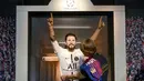 Seorang tim potret museum lilin Madame Tussauds Berlin, Karen Fries memakaikan jersey Paris Saint-Germain untuk patung lilin Lionel Messi di Madame Tussauds Berlin, Jerman, Rabu (11/7/2021). (AP Photo/Britta Pedersen/dpa via AP)