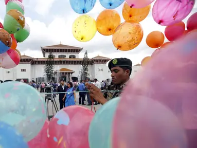 Seorang tentara memasang balon di depan gedung parlemen jelang Presiden Ram Baran Yadav resmi mengesahkan konstitusi baru di Kathmandu, Nepal, Minggu (20/9/2015). Nepal akan mengadopsi piagam demokratis secara penuh. (REUTERS/Navesh Chitrakar)