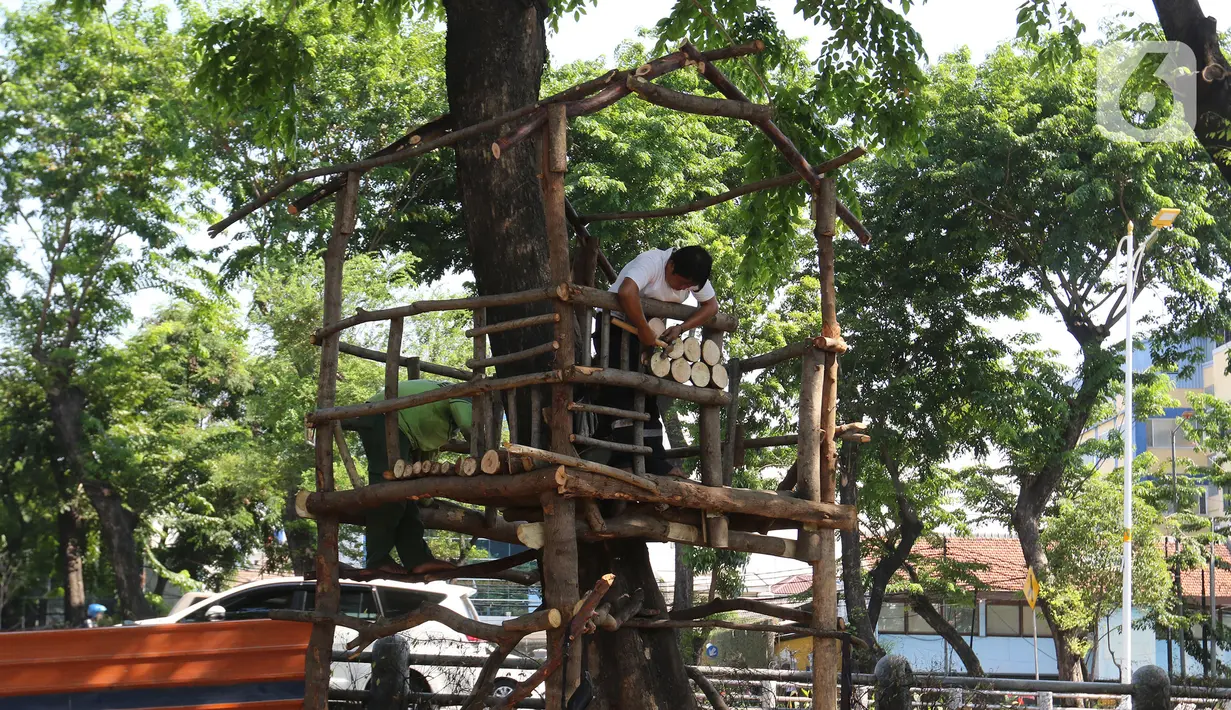 Petugas Dinas Kehutanan Jakarta Barat menyelesaikan pembangunan rumah pohon di kawasan Tomang, Jakarta, Selasa (19/11/2019). Pembangunan taman tersebut dilengkapi dengan rumah pohon untuk menambah ruang bermain anak. (Liputan6.com/Herman Zakharia)
