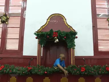Pekerja merapikan ornamen Natal di Gereja Tugu, Jakarta, Senin (23/12/2019). Sejumlah perlengkapan ibadah telah disiapkan untuk menyambut Natal. (Liputan6.com/Herman Zakharia)