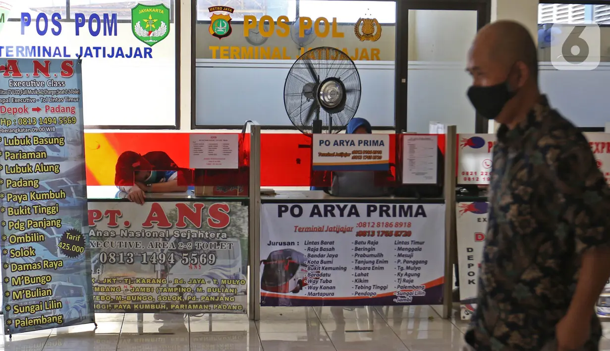 Calon penumpang melintas di depan agen tiket bus di Terminal Jatijajar, Depok, Jawa Barat, Senin (6/7/2020). Terminal tipe A tersebut kembali mengoperasikan layanan bus Antar Kota Antar Provinsi (AKAP) dengan menerapkan protokol kesehatan. (Liputan6.com/Herman Zakharia)