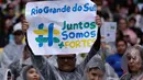 Suporter mengangkat poster bertuliskan "Rio Grande do Sul Bersama Kita Lebih Kuat" saat menyaksikan pertandingan sepak bola di stadion Maracana, Rio de Janeiro, Minggu, 26 Mei 2024. (AP Photo/Bruna Prado)
