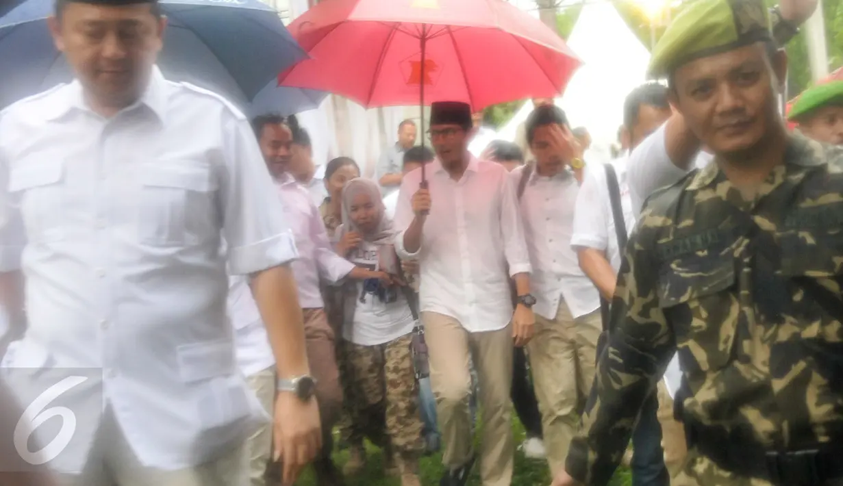 Cawagub DKI Jakarta, Sandiaga Uno tiba di kantor DPP Gerindra, Jakarta, Rabu (19/4). Diguyur hujan, Sandiaga Uno datangi kantor DPP Gerindra untuk merayakan kemenangan hasil hitung cepat suara Pilkada DKI Jakarta. (Liputan6.com/Yoppy Renato)
