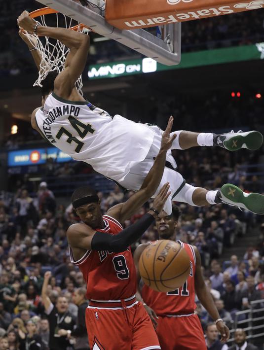 Aksi pemain Milwaukee Bucks,  Giannis Antetokounmpo melakukan dunks  melewati pemain Chicago Bulls pada lanjutan NBA di BMO Harris Bradley Center, (15/12/2016). Bucks menang 108-97.  (AP/Morry Gash)