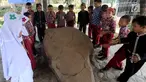 Murid SD melihat prasasti telapak kaki gajah di Prasasti Kebun Kopi, Ciaruteun Ilir, Bogor, Jawa Barat, Rabu (15/8). Prasasti ini peninggalan budaya Kerajaan Tarumanegara yang berdiri pada abad 4 hingga 7 masehi di Pasundan. (Merdeka.com/Arie Basuki)