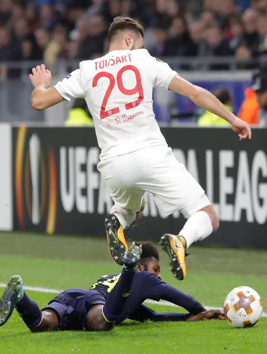 Pemain Everton, Beni Baningime berebut bola dengan pemain Olympique Lyonnais, Lucas Tousart pada laga Grup E Liga Europa di Stadion Stade de Lyon, Kamis (2/11). Everton tersingkir dari Liga Europa setelah dibantai oleh Lyon 3-0. (AP/Laurent Cipriani)