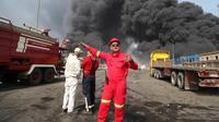 Pemadam kebakaran bekerja saat asap hitam mengepul di langit setelah ledakan dahsyat mengguncang pelabuhan dekat kota selatan Bandar Abbas, Iran, Sabtu (26/4/2025) (Mohammad Rasoul Moradi/IRNA via AP Photo)