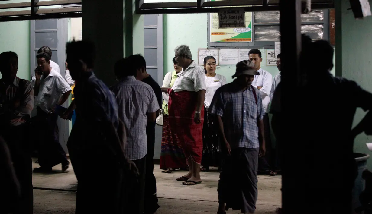 Sejumlah orang berkumpul di luar kamar mayat rumah sakit di pinggiran kota Yangon, Minggu (29/1). Seorang pengacara Muslim terkemuka dan anggota dari partai yang berkuasa di Myanmar itu ditembak mati di bandara internasional Yangon. (AP Photo/Thein Zaw)
