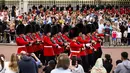 Orang-orang menyaksikan prosesi pergantian penjaga di Istana Buckingham, London, Senin (23/8/2021). Pergantian pasukan jaga yang dilengkapi dengan alat musik lengkap ala marching band tersebut berlangsung untuk pertama kalinya sejak dimulainya pandemi corona Covid-19. (AP Photo/Alberto Pezzali)