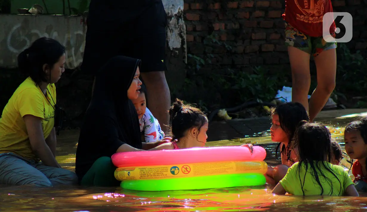 Sejumlah anak bermain air di Jalan Raya Kayu Putih, Jakarta, Minggu (23/2/2020). Usai hujan deras sejak Sabtu (22/2) malam hingga dini hari menyebabkan banjir di Jalan Raya Kayu Putih, Jakarta, Minggu (23/2). (merdeka.com/Magang/Muhammad Fayyadh)