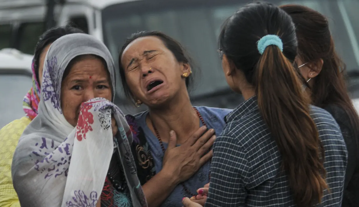 Seorang kerabat menangis ketika jenazah korban jatuhnya helikopter tiba di sebuah rumah sakit di Ibu Kota Nepal, Kathmandu, Senin (8/8). Sebuah helikopter dilaporkan menabrak bukit dan menewaskan tujuh penumpang, termasuk bayi. (AFP PHOTO/BIKASH Karki)