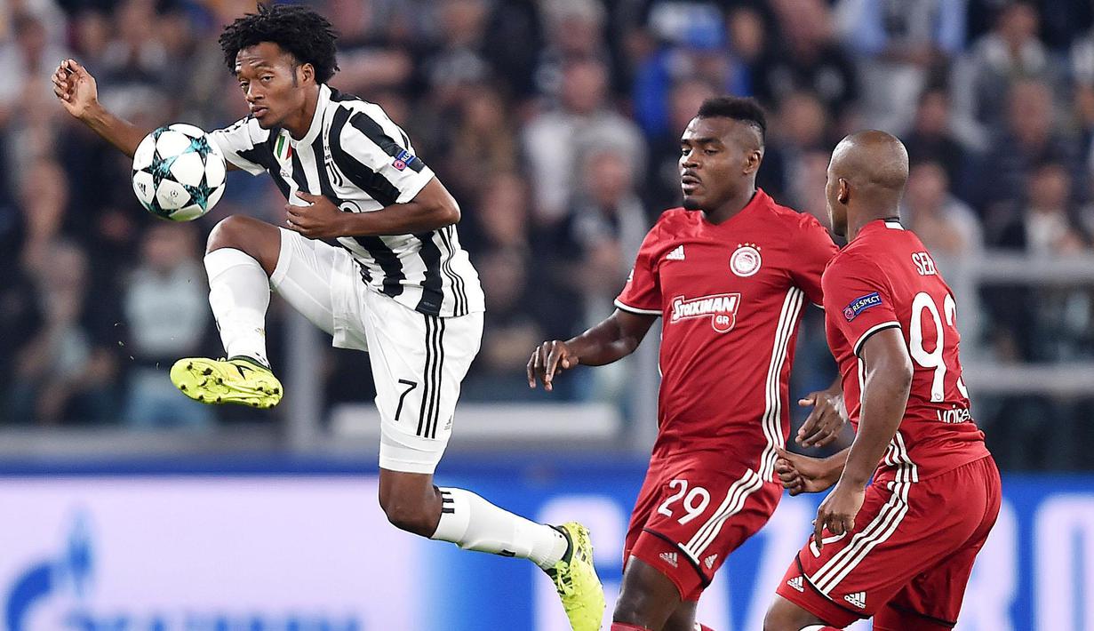 Pemain Juventus, Juan Cuadrado (kiri) mengontrol bola saat diadang para pemain Olympiakos pada laga grup D Liga Champions di Allianz stadium, Turin, (27/9/2017). Juventus menang 2-0. (Alessandro Di Marco/ANSA via AP)