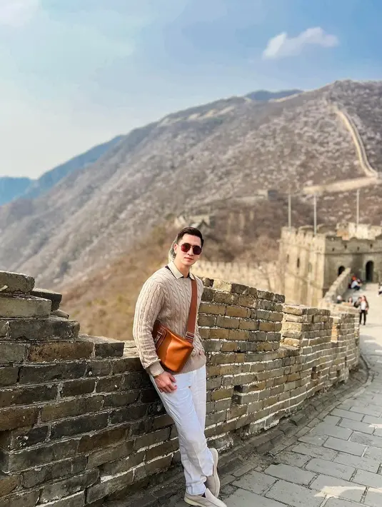 Kunjungi Tembok Besar Tiongkok, Verrel tampil memesona bergaya kasual dengan padu padan kaus berkerah, sweater warna nude, long pants warna putih, dan slip on shoes warna senada dengan sweaternya.  [@bramastavrl]