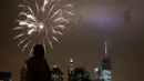 Warga mengamati pesta kembang api di langit Manhattan, New York, saat perayaan hari kemerdekaan Amerika Serikat (AS) , Senin (4/7). AS merayakan hari ulang tahun kemerdekaan yang ke-240 dari Inggris. (KENA Betancur/AFP)