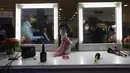 Refleksi seorang perempuan di cermin saat memotong rambut dalam acara Bulan Peduli Kanker Payudara di sebuah mal di Caracas, Venezuela, Sabtu (16/10/2021). Rambut yang dipotong akan disumbangkan untuk membuat wig bagi pasien kanker. (AP Photo/Ariana Cubillos)