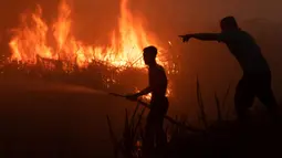 Seorang pemilik perkebunan cabai berusaha memadamkan kobaran api di lahan gambut untuk melindungi lahan miliknya di Ogan Ilir, Sumatra Selatan. Foto diambil pada tanggal 2 Oktober 2023. (Al ZULKIFLI/AFP)