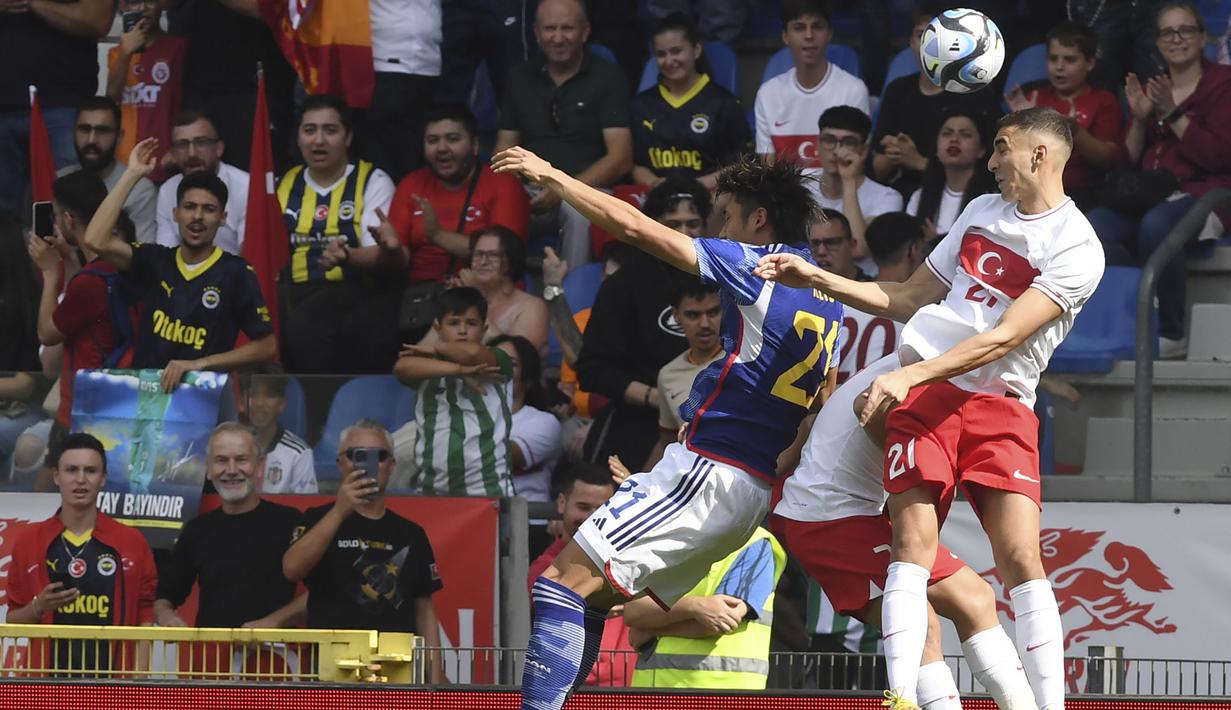 Bek Timnas Turki, Mert Muldur (kanan) memenangi duel udara dengan bek Timnas Jepang, Hiroki Ito pada laga persahabatan FIFA Matchday di Luminus Arena, Genk, Belgia, Selasa (12/9/2023) malam WIB. (AP Photo/Frederic Sierakowski)