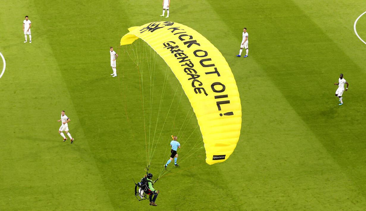 Aktivis Greenpeace menggunakan paraglider mendarat di lapangan sebelum pertandingan Jerman melawan Prancis dalam penyisihan Grup F Piala Eropa di Allianz Arena, Munich, (15/6/2021). (AP/ctivist Alexander Hassenstein, Pool)
