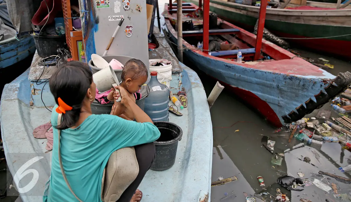 Seorang ibu memandikan anaknya di atas kapal pasca penggusuran permukiman Pasar Ikan, Jakarta, Selasa (13/4). Warga Pasar Ikan mengaku belum mendapat rumah susun sewa yang telah dijanjikan oleh Pemprov DKI Jakarta. (Liputan6.com/Faizal Fanani)