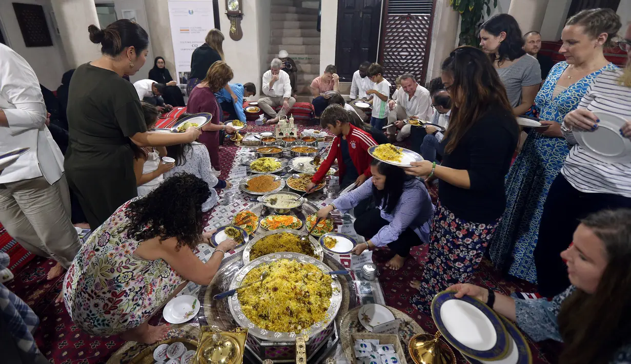 Wisatawan asing memakan hidangan iftar saat belajar tentang puasa dan budaya Uni Emirat Arab (UEA) selama Ramadan di Sheikh Mohammed Centre for Cultural Understanding (SMCCU), Dubai, UEA, Jumat (17/5/2019). (REUTERS/Satish Kumar)