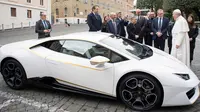 Paus Fransiskus saat menerima hadiah mobil Lamborghini Huracan di Vatikan, Rabu (15/11). Perusahaan Lamborghini memberi hadiah mobil Lamborghini Huracan berwarna putih untuk Paus Fransiskus. (L'Osservatore Romano/Pool Photo via AP)