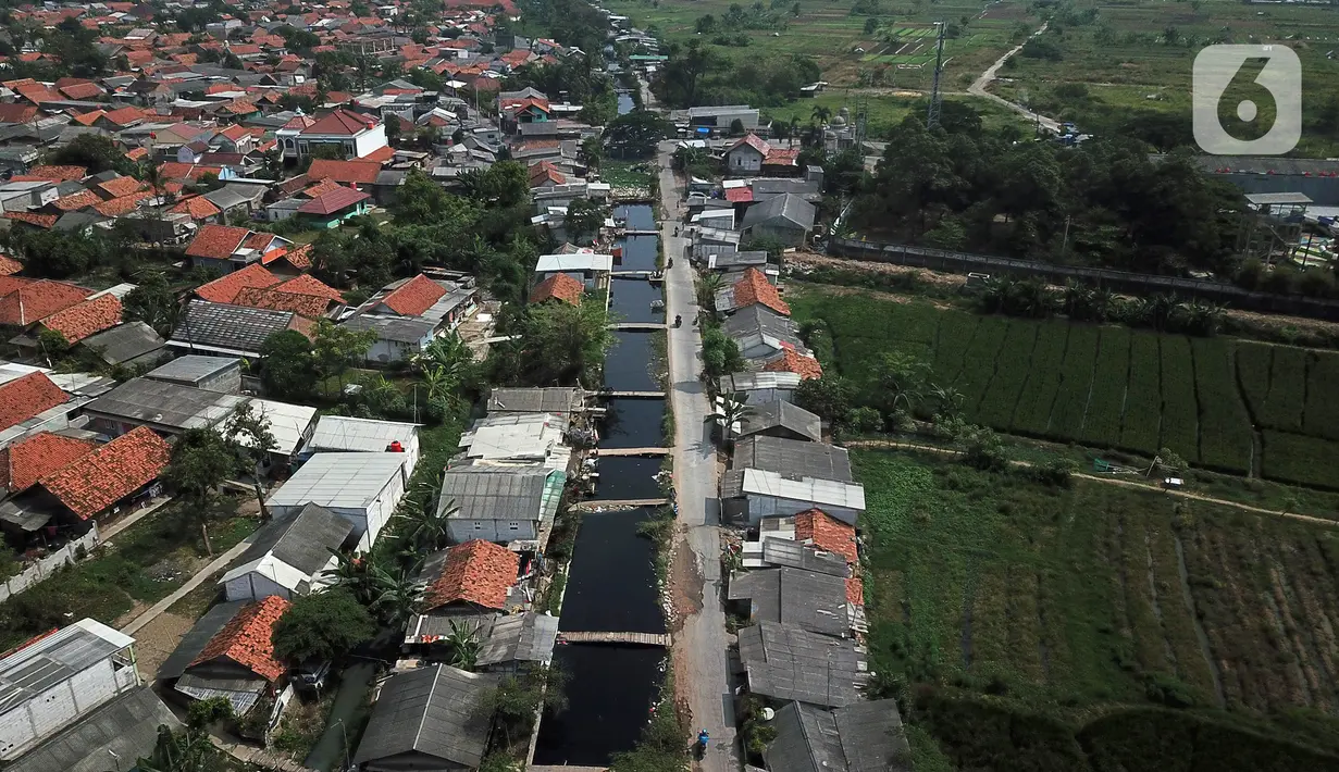 Foto udara aliran Kali Cilemahabang yang menghitam di kawasan Karangbahagia, Kabupaten Bekasi, Jawa Barat, Selasa (7/9/2021). Warga memanfaatkan aliran Kali Cilemahabang yang menghitam dan mengeluarkan bau tak sedap untuk mencuci baju hingga mandi. (Liputan6.com/ Herman Zakharia)